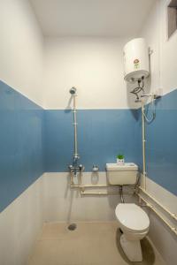 a bathroom with a white toilet and a blue wall at Bir Downtown in Bīr