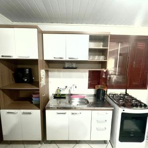 a small kitchen with white cabinets and a stove at Blue 52 in Torres