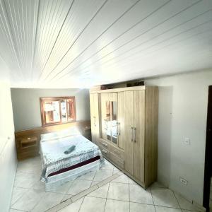 a bedroom with a bed and a wooden cabinet at Blue 52 in Torres