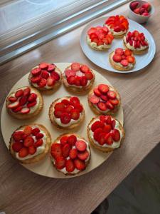 a table topped with pies with strawberries on top at Vila Sopot lux in Risti°i