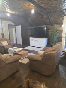 a living room with two couches and a flat screen tv at Vila Sopot lux in Risti°i
