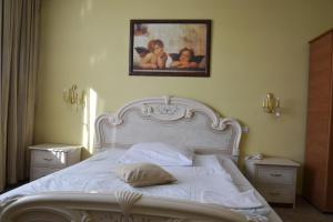 a bedroom with a white bed with a picture on the wall at Hotel Restauracja Małopolska in Jasło