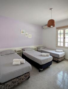 a room with three beds and a window at Roque 4047 in San Juan
