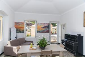 a living room with a couch and a piano at Hostel Bosmi Bed&Language Liguria in Sori
