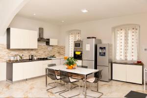 a kitchen with a table with chairs and a refrigerator at Hostel Bosmi Bed&Language Liguria in Sori