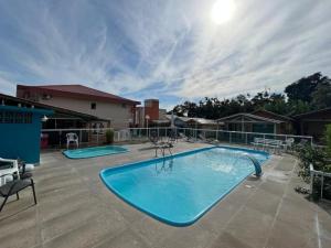 a large swimming pool with two chairs and a patio at Pousada Recanto Armação in Penha