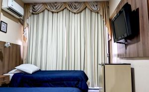 a hotel room with a bed and a television at Hotel Presidente Asunción in Asunción