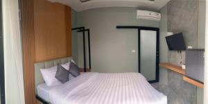 a bedroom with a bed with white sheets and pillows at Adira Residence in Ao Nang Beach