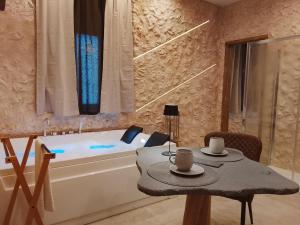 a bathroom with a table and a bath tub at suite pompei La Caverna in Pompei