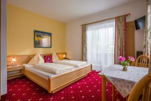 a hotel room with a bed and a table at Hotel Alpenhof in Westendorf +50 photos