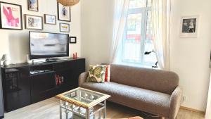 a living room with a couch and a tv at Bright Cozy Apartment in Riga Quiet Center in Riga