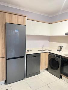 a kitchen with a refrigerator and a dishwasher at Lagoon escape Apartment in Pretoria +8 photos