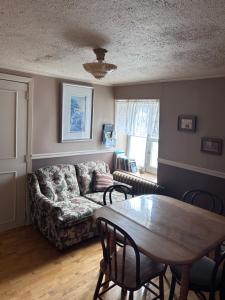 a living room with a couch and a table at Chez Odette, suite international in Roberval