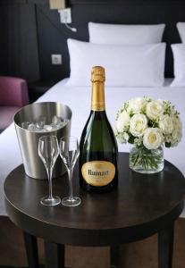 a bottle of champagne and two glasses on a table at Hôtel Aero Paris Passy in Paris