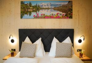 a bedroom with a bed with white pillows and flowers at Urlaub im Denkmal in Gröbming