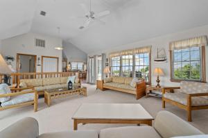 a living room with couches and tables and windows at 5592 - Windjammer in Nags Head