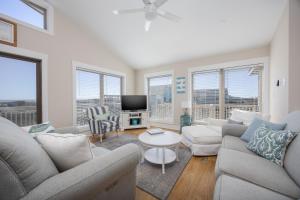 a living room with a couch and a tv at 7158 - A Wave From It All in Waves