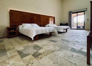 a bedroom with two beds and a large window at Hotel Suites Piamonte in Bernal