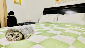 a bed with a green and white comforter on it at Joshiehome in Rancho Cucamonga