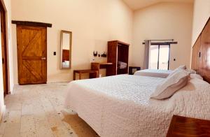 a bedroom with a white bed and a wooden door at Hotel Suites Piamonte in Bernal +61 photos
