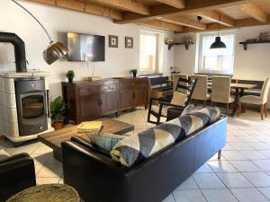 a living room with a couch and a stove at My Sweet Home In The Dolomites - Casa LaLu in Cavalese