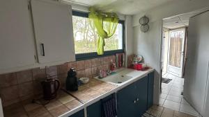 a kitchen with a sink and a window at Petit studio cosy in Cersay