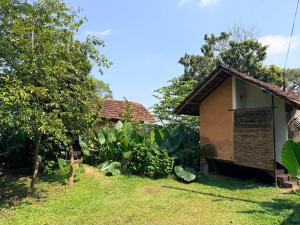 a house with a yard next to a tree at Lake Cabin in Polonnaruwa +97 photos