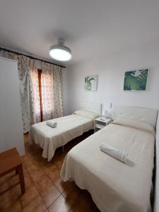 a room with three beds in it with a light at Casa de playa los Alamos Andra in Torremolinos