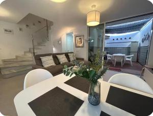a living room with a couch and a table and chairs at Casa de playa los Alamos Andra in Torremolinos