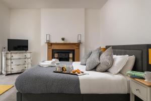a bedroom with a bed with a tray of food on it at Tides Door in Dartmouth