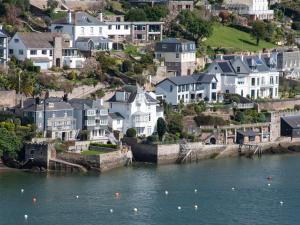 a group of houses on a hill next to a body of water at Tides Door in Dartmouth