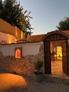 an entrance to a stone wall with a potted plant at Adyton Guest House in Didim