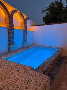 a swimming pool in a backyard with two columns at Adyton Guest House in Didim
