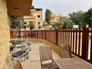a patio with two chairs and a swing at Les Voiles Kfar Aabida in Fad‘ūs