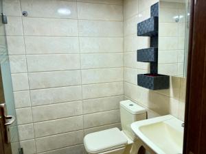 a bathroom with a toilet and a sink at Les Voiles Kfar Aabida in Fad‘ūs