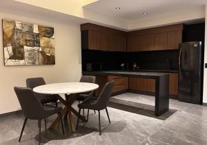 a kitchen with a table and chairs and a refrigerator at Hotel Suites Regente Cholula in Cholula +30 photos