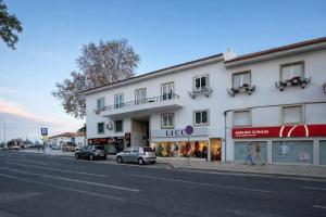 a white building with cars parked on the side of a street at Cascais Ocean Apartment in Cascais