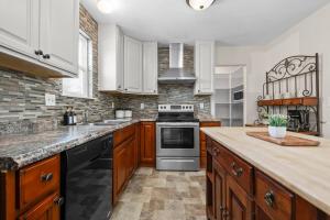a kitchen with wooden cabinets and a stove top oven at Cozy Orem House - Playground - Game Rm - Bunk Rm in Orem