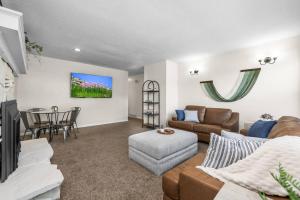 a living room with a couch and a table at Cozy Orem House - Playground - Game Rm - Bunk Rm in Orem