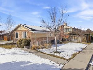 a brick house with a fence in the snow at Cozy Orem House - Playground - Game Rm - Bunk Rm in Orem