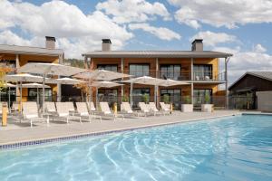 a pool with chairs and umbrellas in front of a building at Appellation Healdsburg in Healdsburg