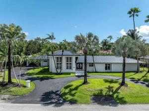 a house with palm trees in front of a driveway at Guest Fav | 5BR Pool Estate | Sleeps 16 in Palmetto Bay