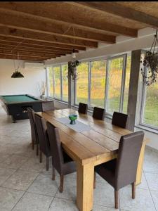 a dining room with a large wooden table and chairs at Imanje Mihailovic 3 in Pružatovac