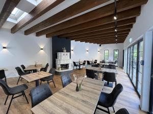a restaurant with tables and chairs and a fireplace at Haus Kuckenberg in Burscheid