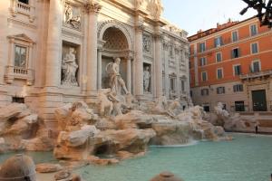 una fontana di fronte a un edificio con statue di Trevi Fountain 2BR Apartment a Roma
