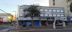a city street with a palm tree in front of a building at Fazio Hotel in Jales