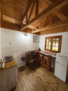 a kitchen with a table and a refrigerator at Cabañas Parana Ranch in Ituzaingó
