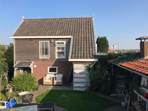 a small house with a backyard with a lawn at De Knol in Hoek