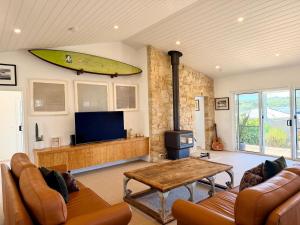 a living room with a surfboard hanging on the wall at Shorebreak Port Campbell in Port Campbell