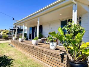 a house with potted plants on a wooden deck at Shorebreak Port Campbell in Port Campbell